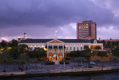 View of buildings in city against cloudy sky