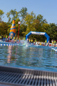 People by swimming pool against sky