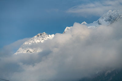 Low angle view of snowcapped mountains against sky