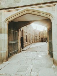 Empty footpath amidst buildings in city