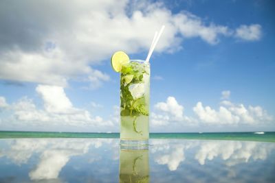 Mojito cocktail on table against sky