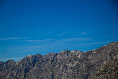 Low angle view of mountain against blue sky