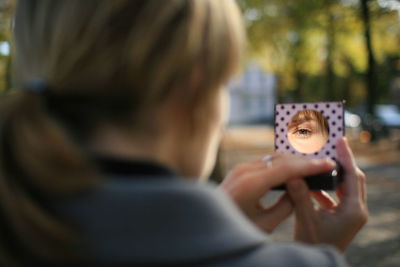 Woman eye reflecting on hand mirror