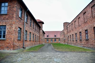 Empty alley amidst buildings against sky