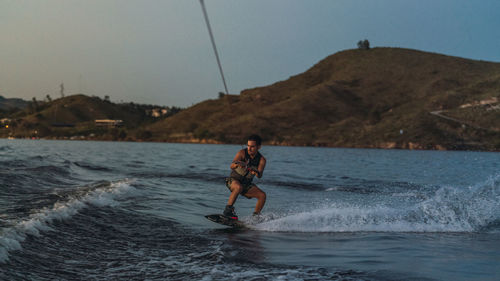 Rear view of man surfing in sea