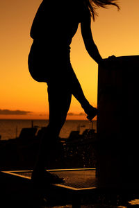 Silhouette man against sea during sunset