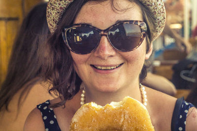 Portrait of woman in sunglasses having food at restaurant