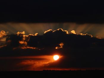 Scenic view of silhouette field against sky at sunset