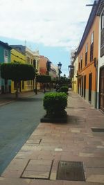 Sidewalk in city against sky