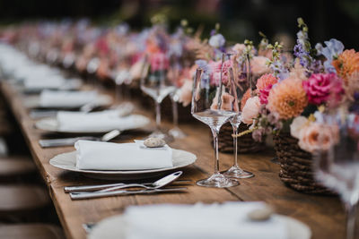 Luxury wedding table decoration detail with flowers and roses and plates with wine glass