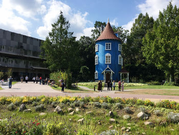 People in front of building against sky