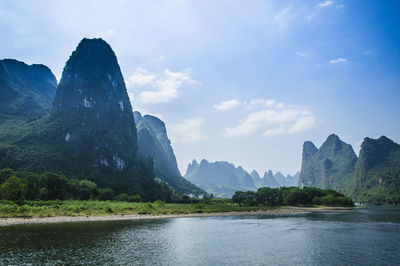 Scenic view of river and mountains against sky