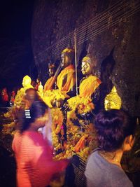 Group of people by statue at night