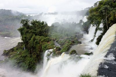 Scenic view of waterfall against sky