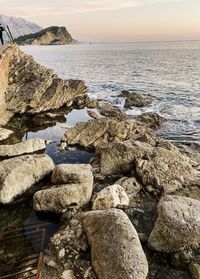 Rocks on sea shore against sky