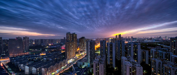 High angle view of illuminated buildings against sky at night