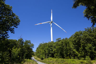 Low angle view of windmill against clear blue sky