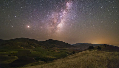 Scenic view of landscape against sky at night