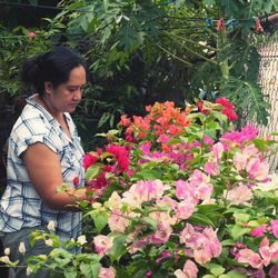 Woman standing by flowering plants