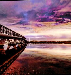 Bridge over river against sky during sunset