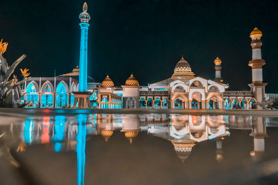 Reflection of illuminated building in water at night