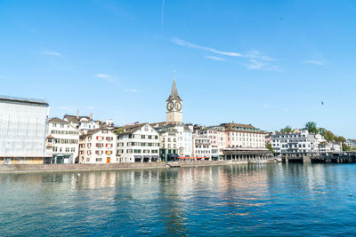 Buildings in city against blue sky