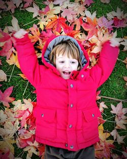 Portrait of cute boy with leaves on field