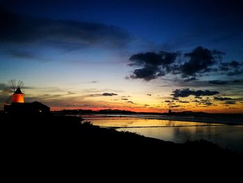 Scenic view of silhouette beach against sky during sunset