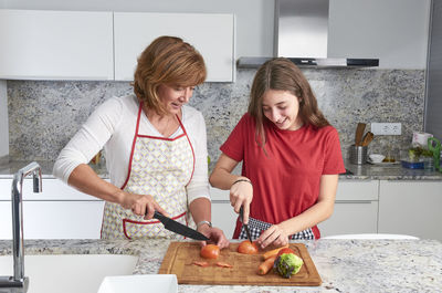 Friends standing on cutting board at home