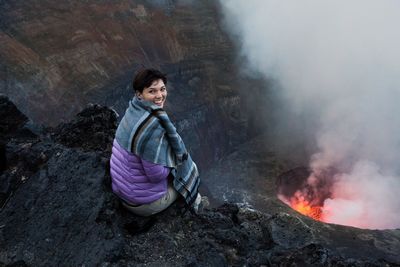 Woman looking at erupting volcano