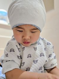 Close-up of boy wearing hat at home