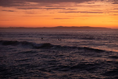 Scenic view of sea against orange sky