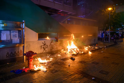 People on illuminated fire in city at night
