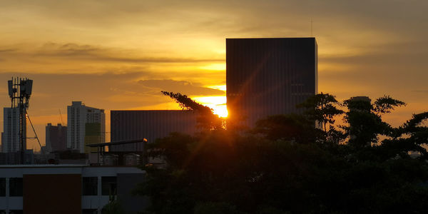 Modern buildings against sky during sunset in city