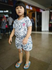 Portrait of cute girl standing on floor