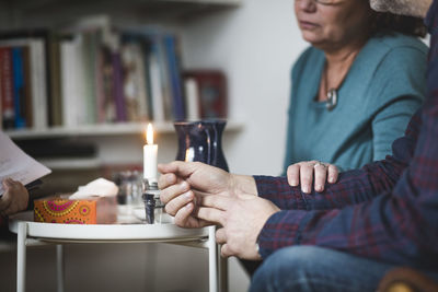 Midsection of mature couple with therapist at home office during session