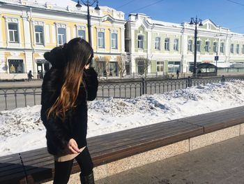 Rear view of woman standing in snow