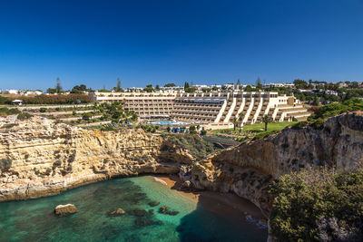 Buildings in city against clear blue sky