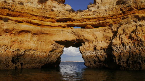 Rock formation in sea against sky
