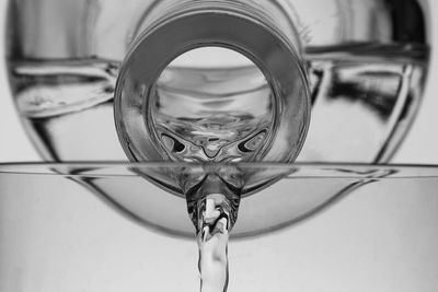 Close-up of water pouring from bottle against white background