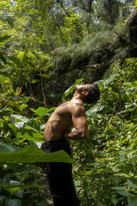 Man seen up close, without shirt doing stretches on yoga mat, exercise, latin america