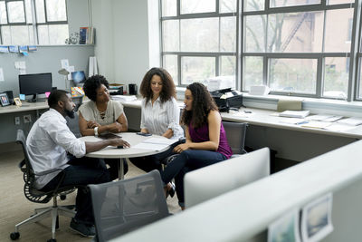 Business people discussing while sitting at table in office