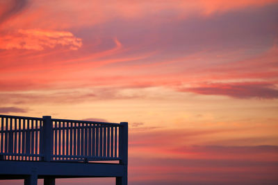 Silhouette built structure against dramatic sky during sunset