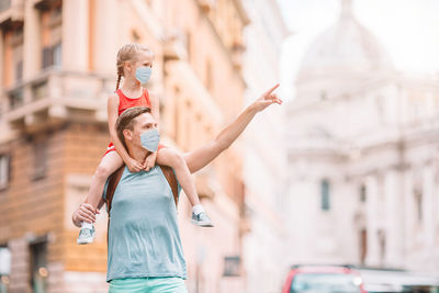 Full length of woman with arms raised in city