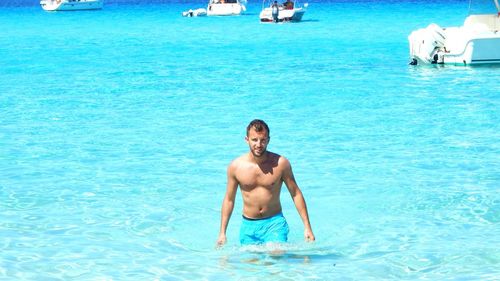 Shirtless handsome young man in sea