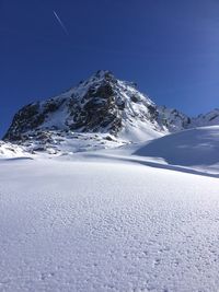 Scenic view of snow covered mountains against clear sky