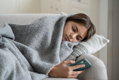 Young woman using mobile phone at home