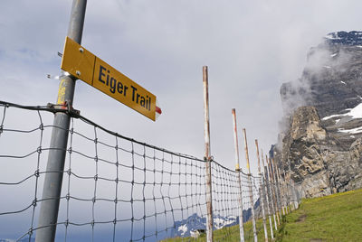 Low angle view of information sign against sky