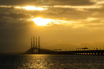 View of bridge over sea against sky during sunset