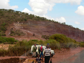 People standing on mountain against sky